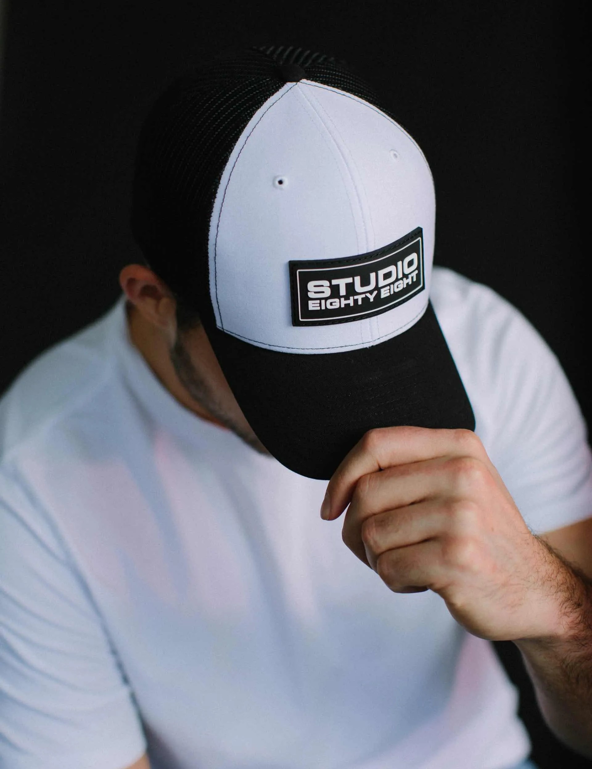 Close up photo of a man wearing a Studio EightyEight hat.