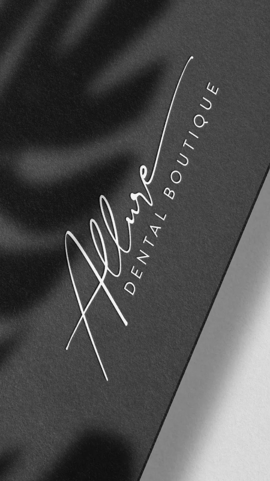 Elegant black business card for allure dental boutique featuring sophisticated white cursive logo with soft shadow effect.