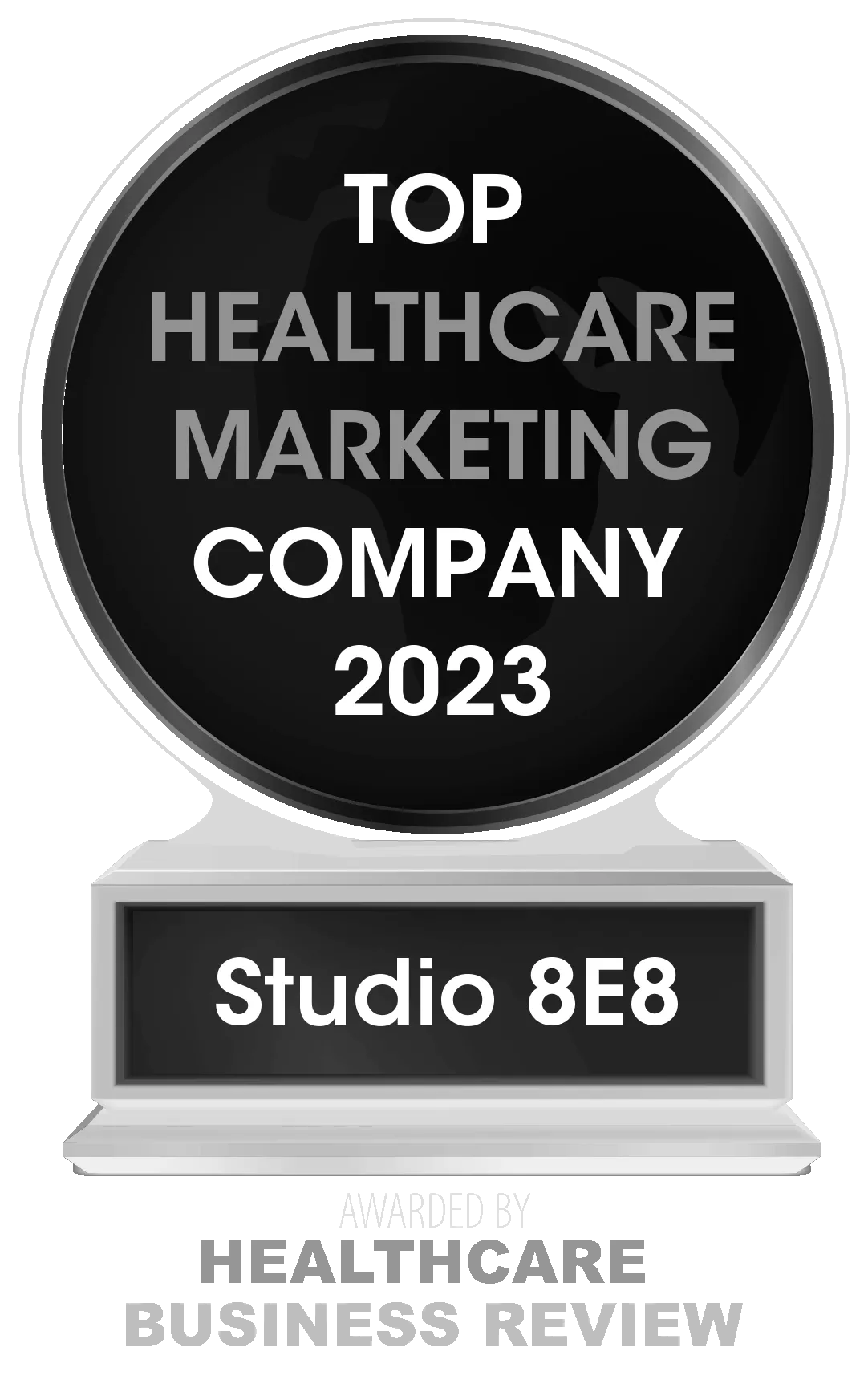 Award trophy with a label "top dental marketing company 2023" for Studio 8e8. Black and silver design, displayed on a transparent stand.